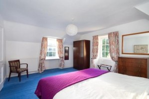 Blue carpet, purple bedding and orange flowery curtains. What more could you want from a room?